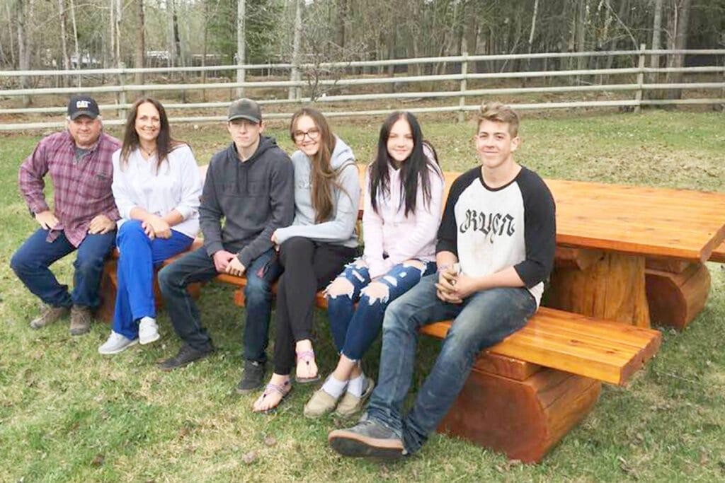 Bonner family sits at 12 foot cedar table they won.